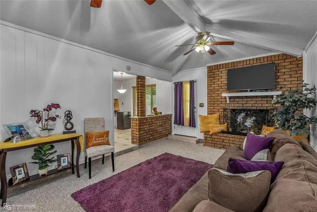 a living room with furniture a flat screen tv and a fireplace
