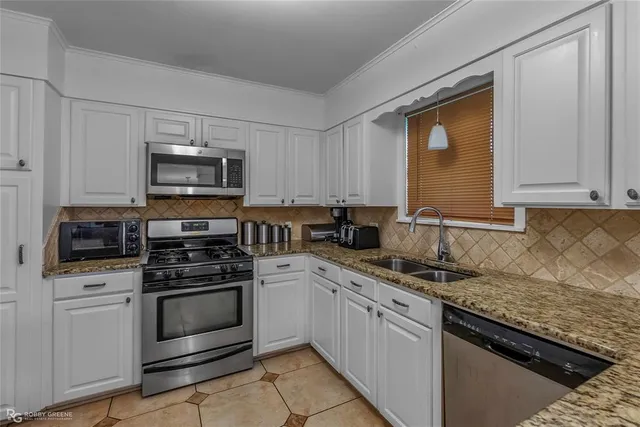 a kitchen with appliances a sink and cabinets
