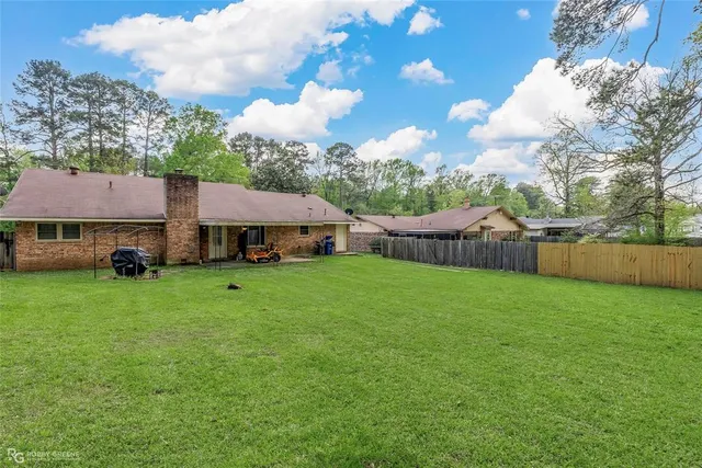 a view of house with backyard and garden