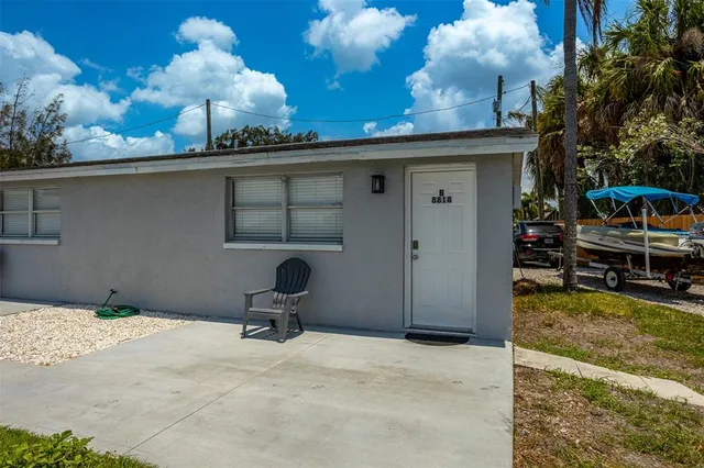 a view of a backyard with a chair and potted plants