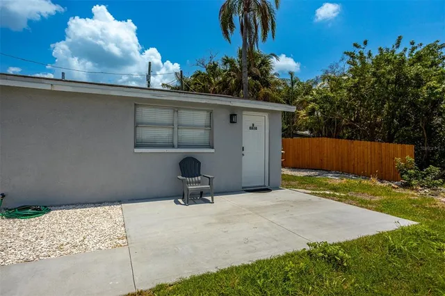a backyard of a house with table and chairs