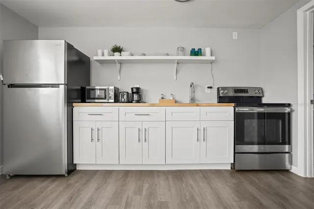 a kitchen with white cabinets and refrigerator