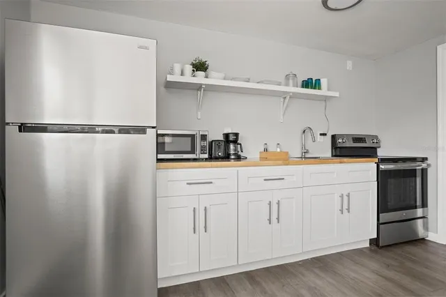 a kitchen with white cabinets and stainless steel appliances