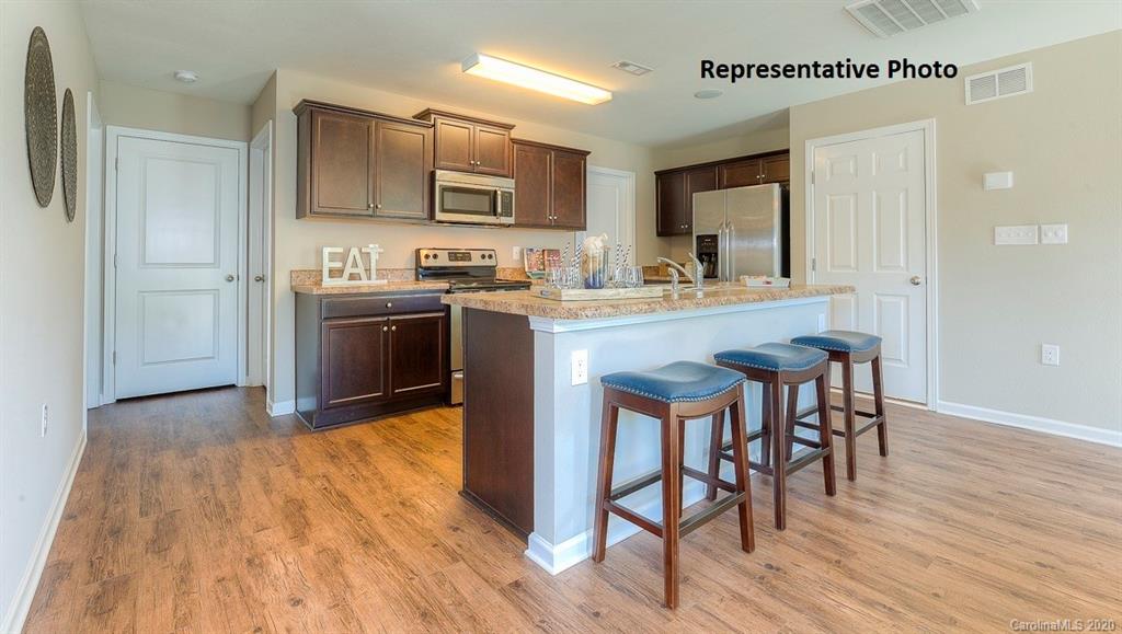 7261 Finnigan Road Charlotte, NC 28215 - Photo 12 of 40 a kitchen with stainless steel appliances granite countertop a table chairs microwave and sink