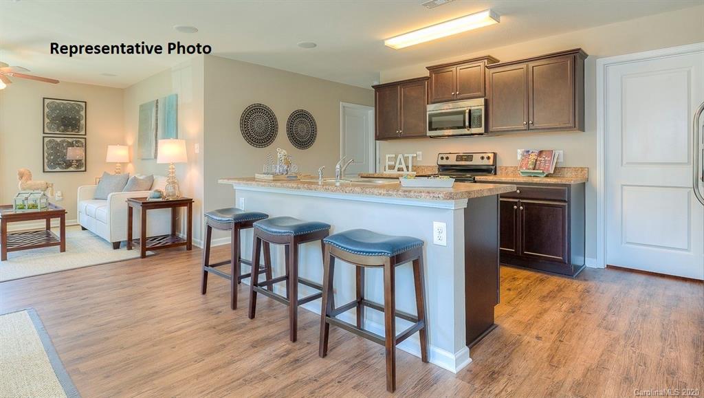 7261 Finnigan Road Charlotte, NC 28215 - Photo 13 of 40 a kitchen with kitchen island granite countertop wooden floors and stainless steel appliances
