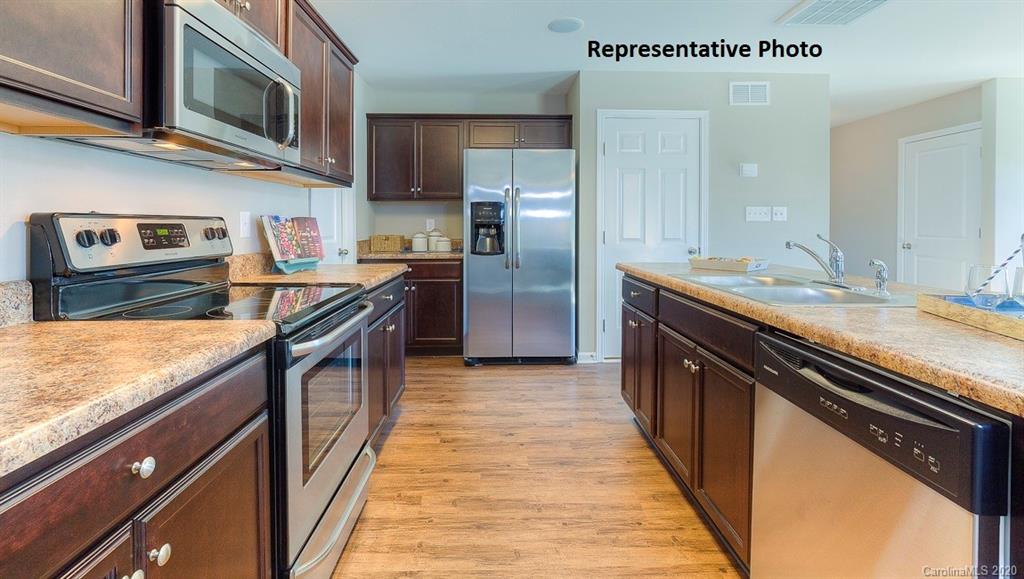 7261 Finnigan Road Charlotte, NC 28215 - Photo 15 of 40 a kitchen with stainless steel appliances granite countertop a kitchen island a stove a sink and a microwave