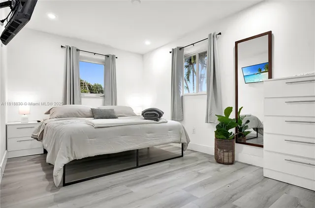 a bedroom with a bed and potted plant