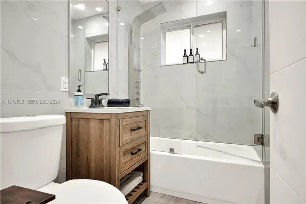 a bathroom with a sink toilet vanity and tub