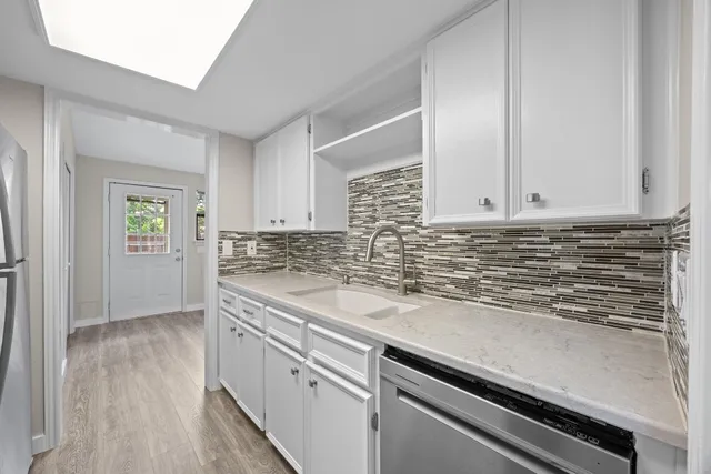 a kitchen with granite countertop white cabinets and white appliances