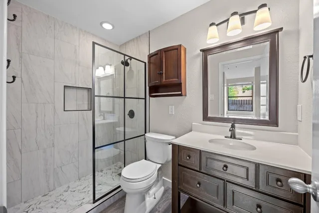 a bathroom with a sink a toilet and shower