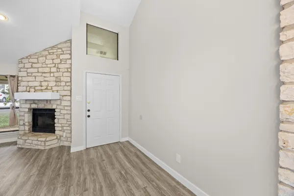 a view of a hallway with wooden floor and a fireplace