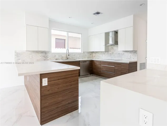 a kitchen with kitchen island a sink and a stove with wooden floor