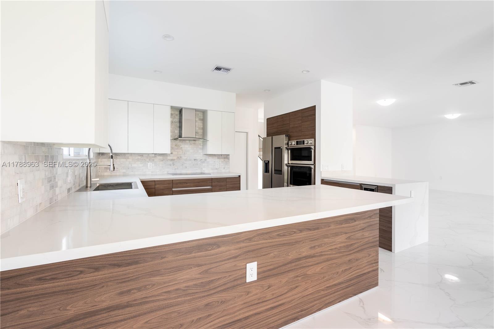 910 Southwest 24th Road Miami, FL 33129 - Photo 13 of 38 a kitchen with kitchen island a sink and a stove with wooden floor