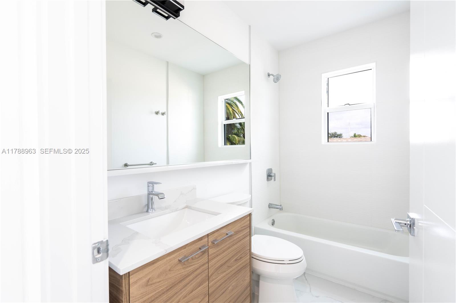 910 Southwest 24th Road Miami, FL 33129 - Photo 23 of 38 a bathroom with a sink a toilet and shower