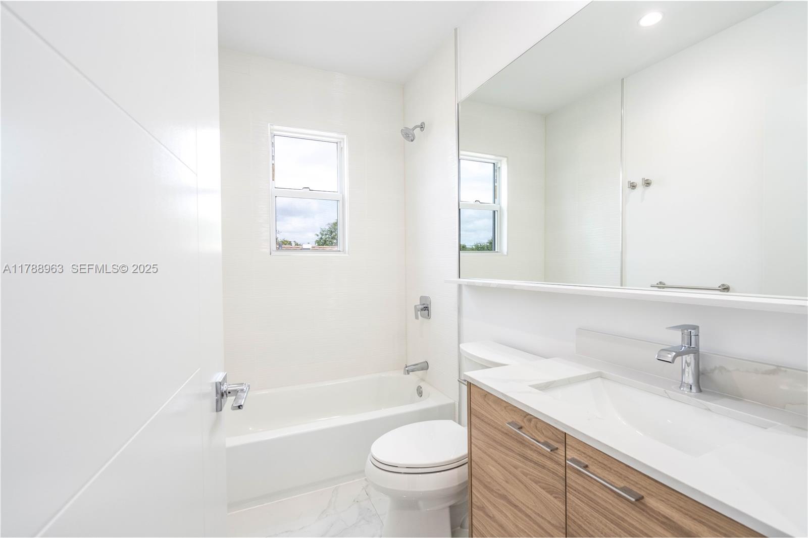 910 Southwest 24th Road Miami, FL 33129 - Photo 25 of 38 a bathroom with a granite countertop sink a toilet and a large mirror