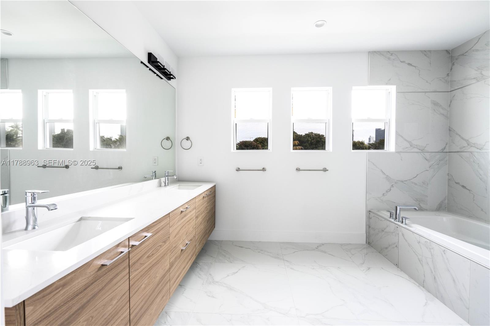 910 Southwest 24th Road Miami, FL 33129 - Photo 29 of 38 a spacious bathroom with a double vanity sink a mirror and a bathtub