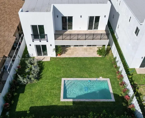 a view of a swimming pool with a yard and a large tree