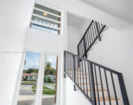 a view of staircase with railing and a window