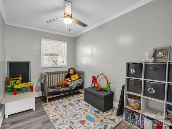 a bedroom with furniture a rug toys and a window