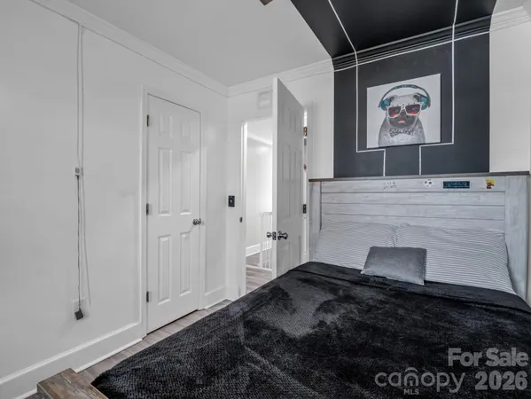 a bedroom with a bed and a painting on the wall