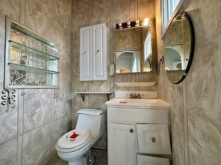 7777 Ramsgate Circle South Hanover Park, IL 60133 - Photo 10 of 26 a bathroom with a toilet sink and mirror