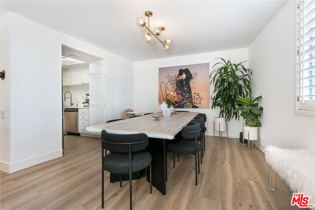 2385 Roscomare Road, Unit D17 Los Angeles, CA 90077 - Photo 12 of 18 a dining room with furniture potted plants and wooden floor