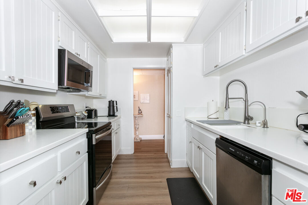 2385 Roscomare Road, Unit D17 Los Angeles, CA 90077 - Photo 13 of 18 a kitchen with stainless steel appliances granite countertop a sink stove microwave and refrigerator