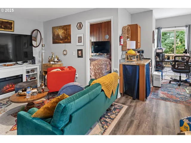 a living room with furniture a flat screen tv and a fireplace