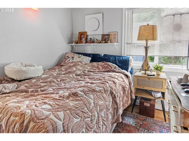 a bedroom with a bed and a lamp with the dresser