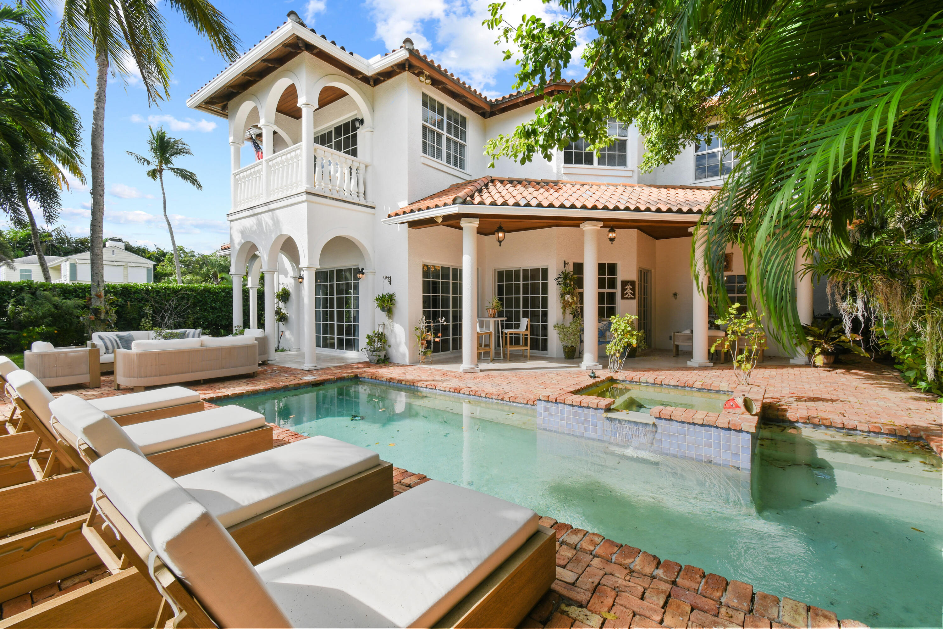 201 Avila Road West Palm Beach, FL 33405 - Photo 3 of 75 a view of a white house with a large pool lawn chairs and a yard