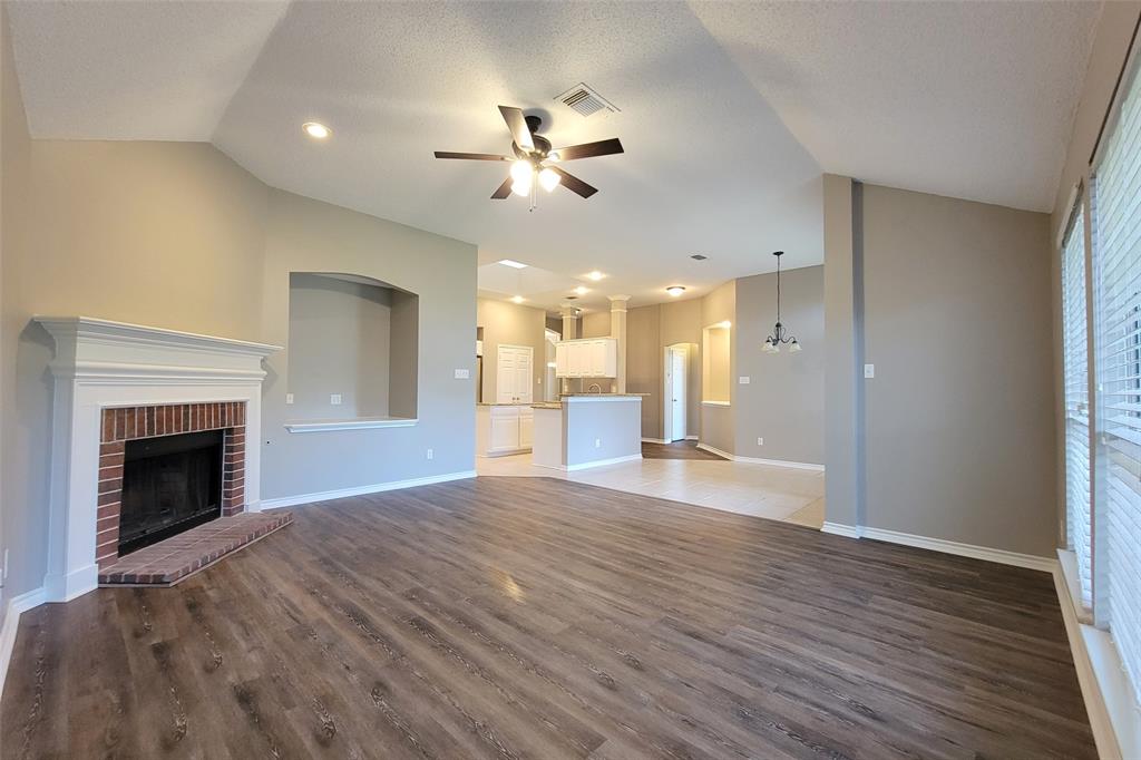 1604 Knoll Ridge Circle Corinth, TX 76210 - Photo 21 of 37 Spacious interior featuring wood-finish flooring, a brick fireplace with a white mantel, and vaulted ceilings with recessed lighting