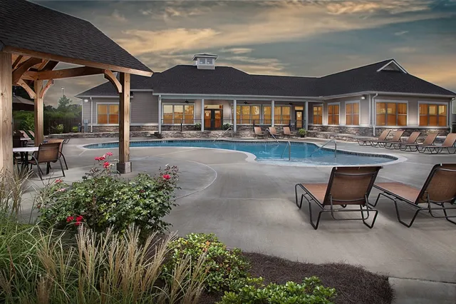 a patio with couches table and chairs and potted plants