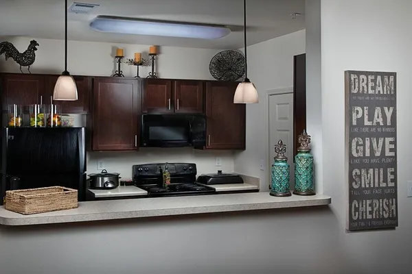 a kitchen with stainless steel appliances granite countertop a sink a stove and a refrigerator