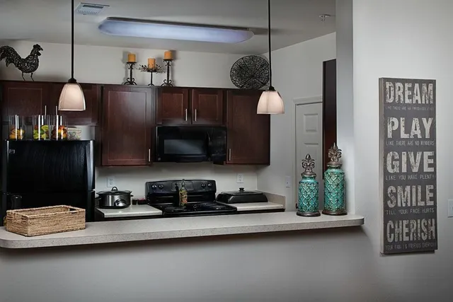 a kitchen with stainless steel appliances granite countertop a sink a stove and a refrigerator