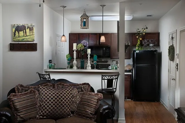 a kitchen with a refrigerator and a wooden floor