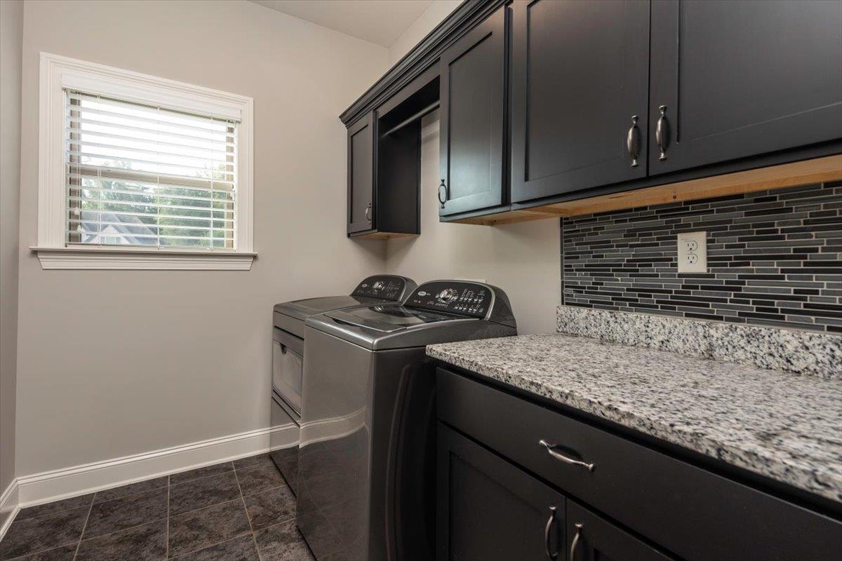 3328 Straw Bridge Road Olive Branch, MS 38654 - Photo 19 of 28 Dark cabinetry, light-toned countertop, tile backsplash, and window with blinds
