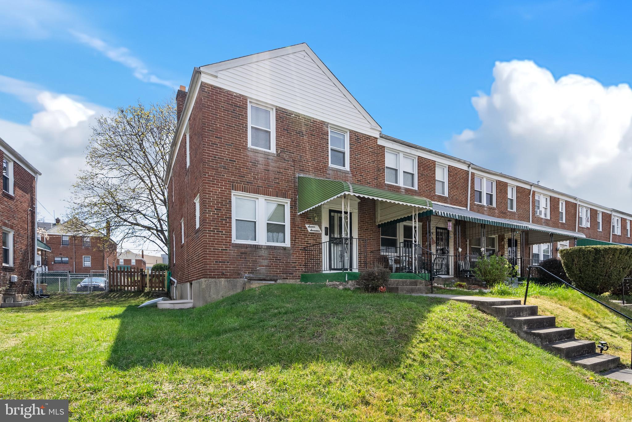 a front view of a house with garden and trees