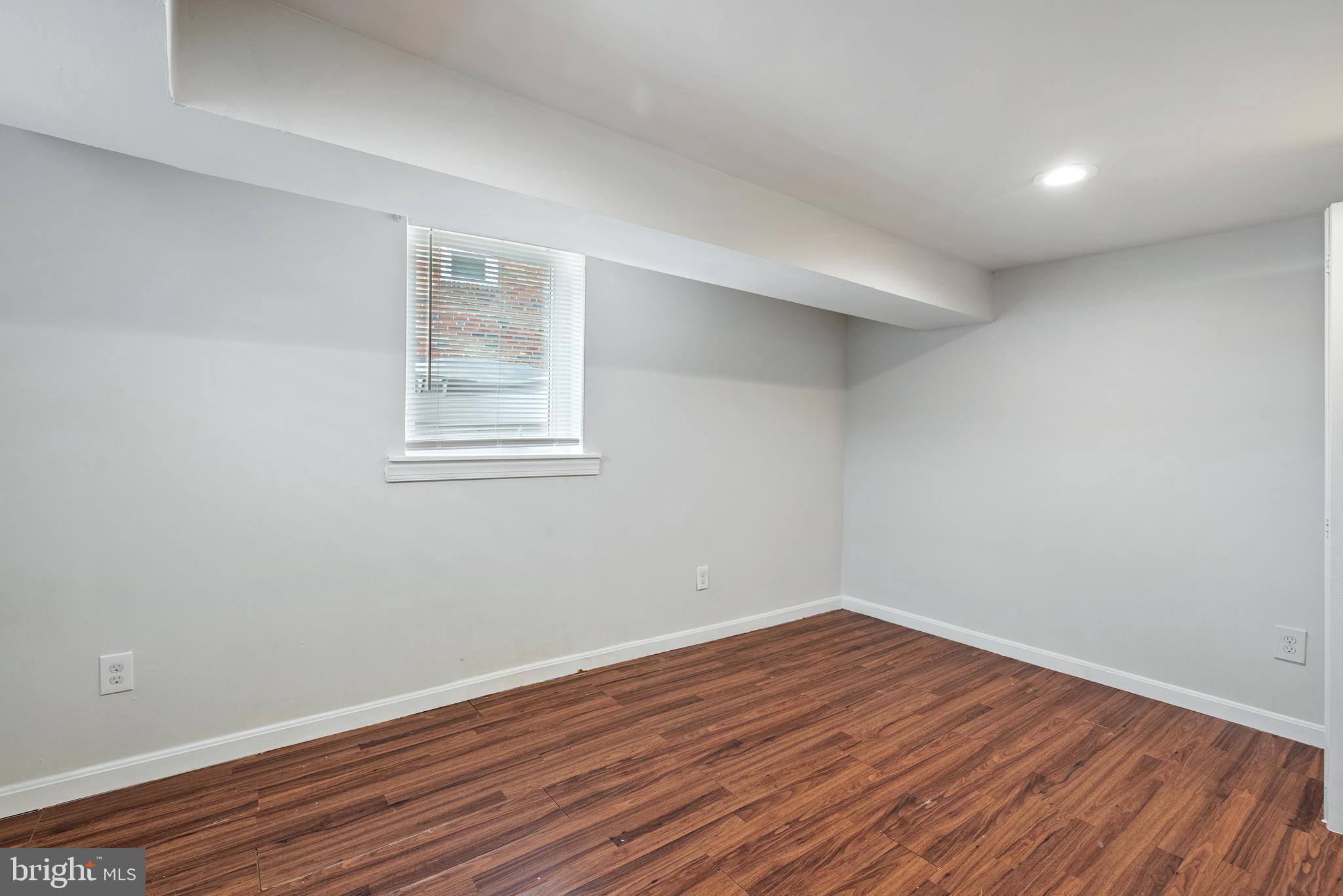 1617 Northwick Road Baltimore, MD 21218 - Photo 11 of 32 a view of an empty room with wooden floor and a window