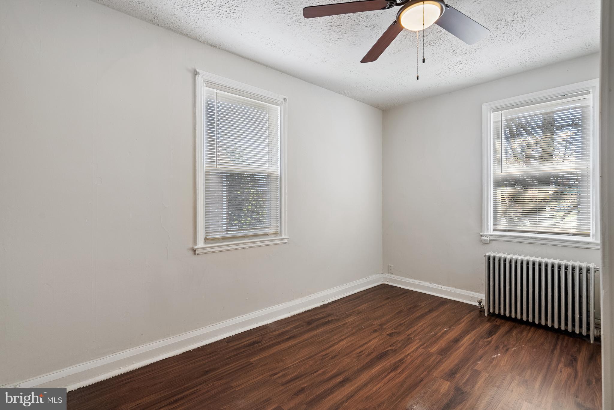 1617 Northwick Road Baltimore, MD 21218 - Photo 16 of 32 a view of an empty room with wooden floor and a window