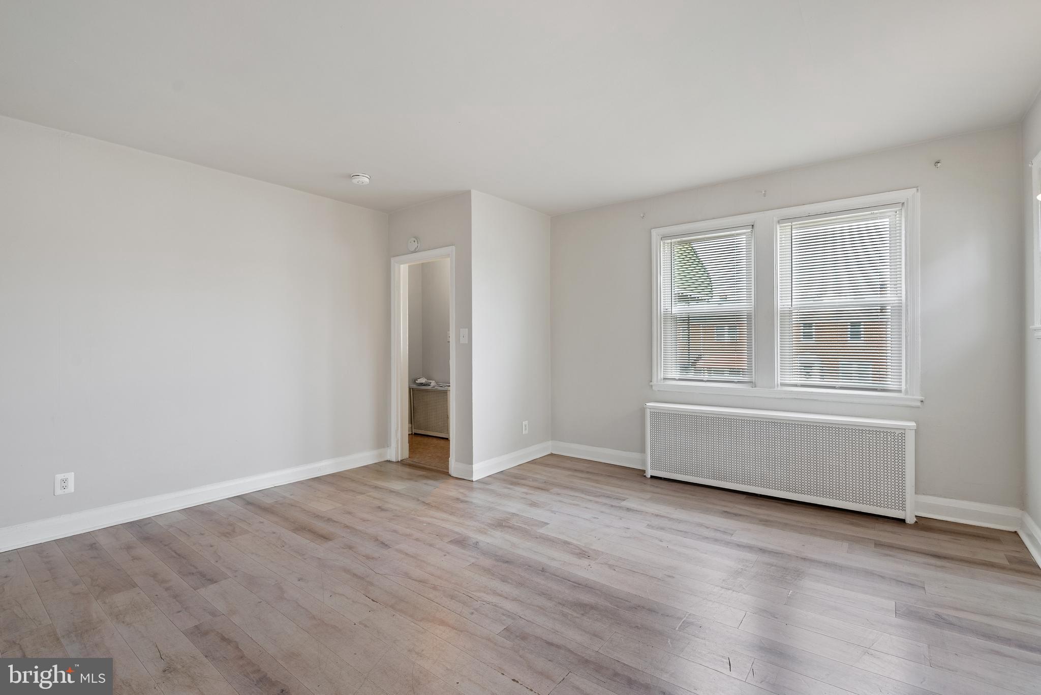 1617 Northwick Road Baltimore, MD 21218 - Photo 7 of 32 an empty room with wooden floor and windows