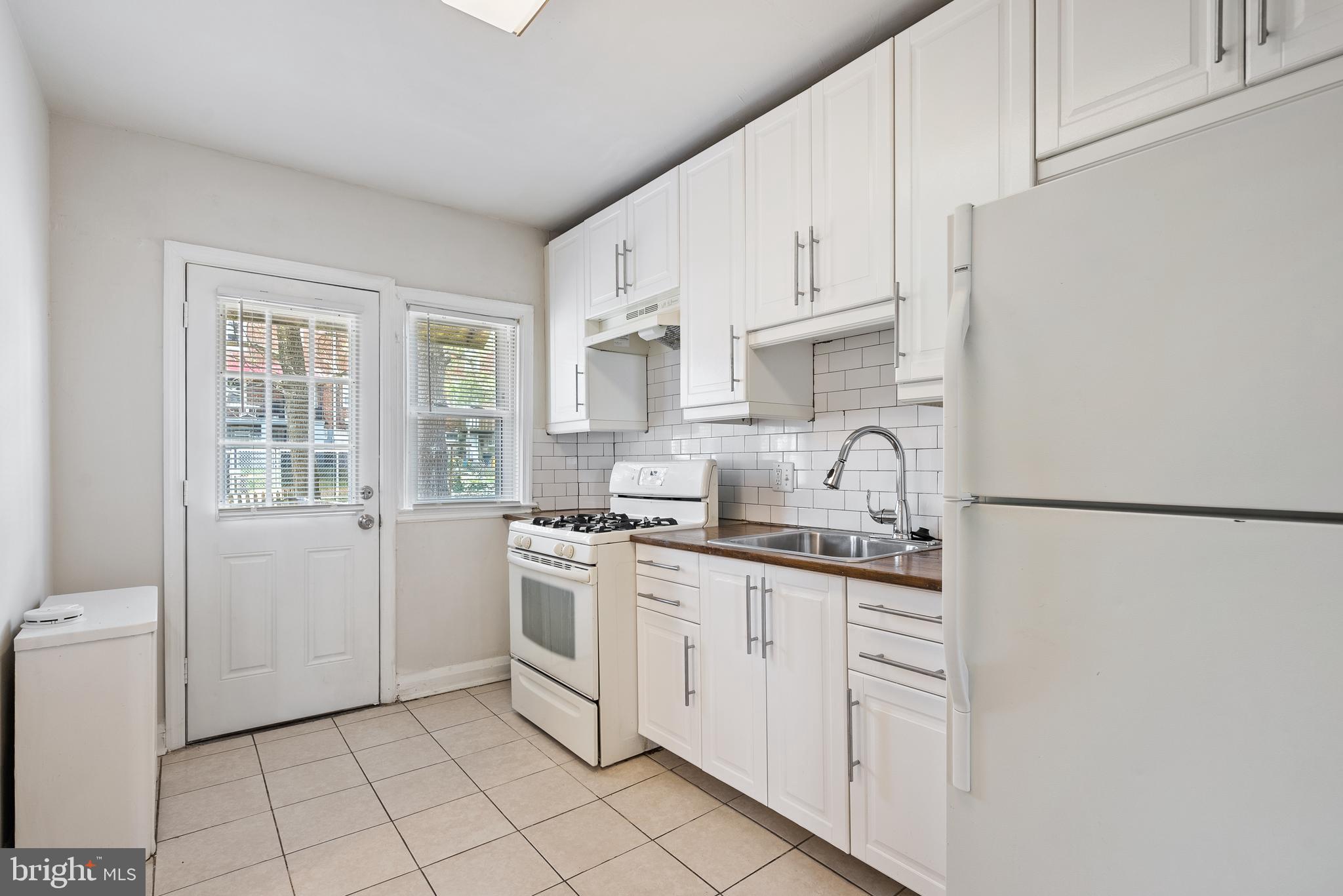 1617 Northwick Road Baltimore, MD 21218 - Photo 9 of 32 a kitchen with white cabinets and white appliances