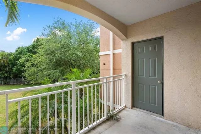 a view of a house with a big yard and large trees