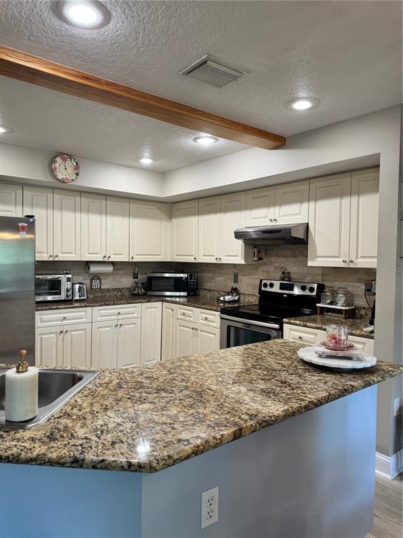 1116 Sunset Point Road, Unit 202 Clearwater, FL 33755 - Photo 11 of 31 a kitchen with stainless steel appliances granite countertop a sink stove and refrigerator