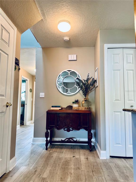1116 Sunset Point Road, Unit 202 Clearwater, FL 33755 - Photo 15 of 31 a living room with furniture a mirror and a wooden floor
