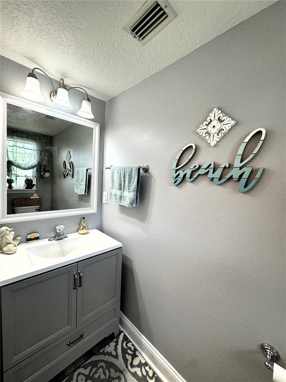 1116 Sunset Point Road, Unit 202 Clearwater, FL 33755 - Photo 27 of 31 a bathroom with a sink mirror and vanity