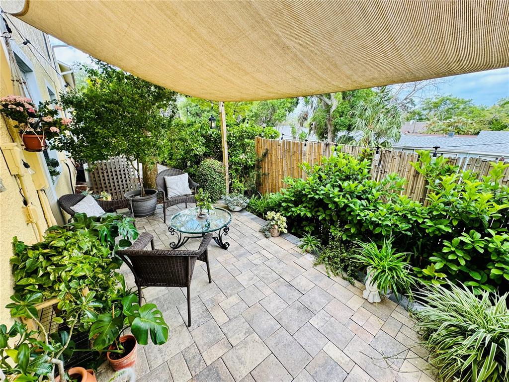 1116 Sunset Point Road, Unit 202 Clearwater, FL 33755 - Photo 28 of 31 a view of a chair and tables in the garden