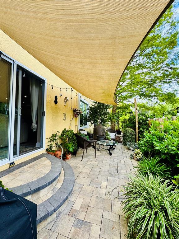 1116 Sunset Point Road, Unit 202 Clearwater, FL 33755 - Photo 29 of 31 a view of a patio with table and chairs and potted plants