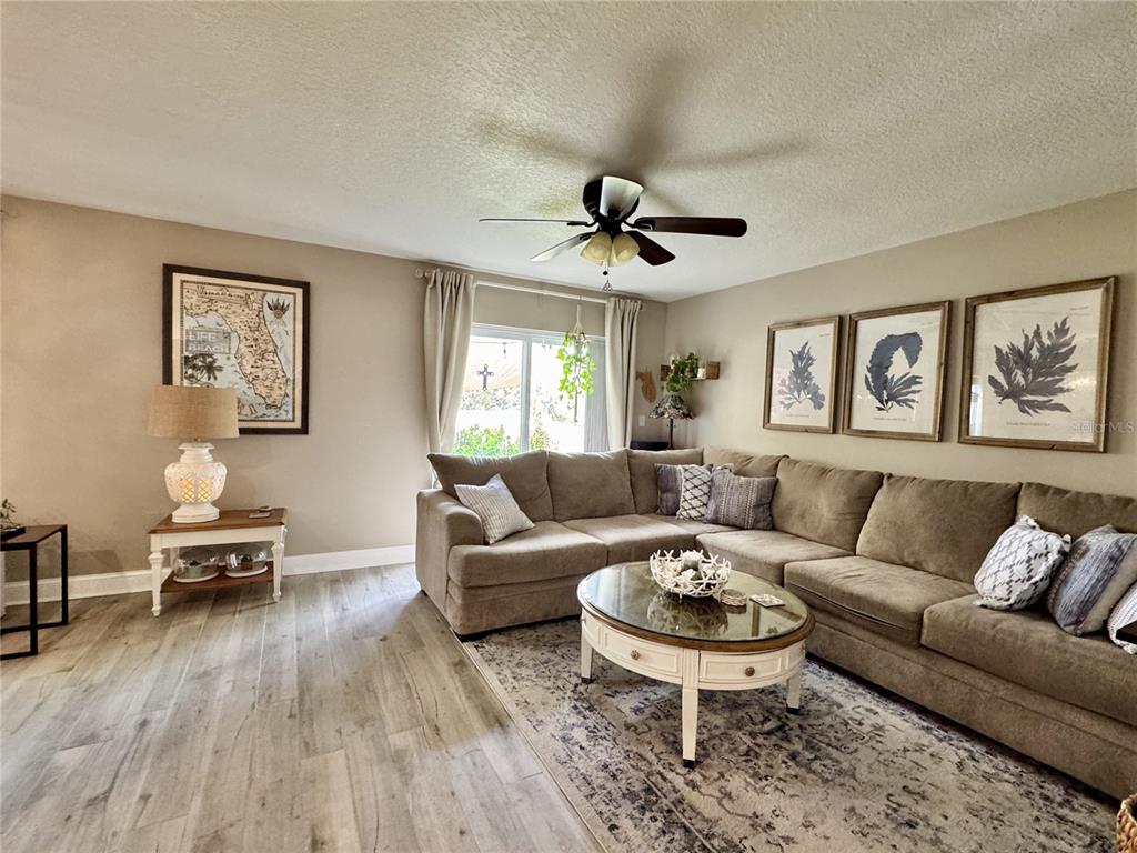 1116 Sunset Point Road, Unit 202 Clearwater, FL 33755 - Photo 6 of 31 a living room with furniture and a wooden floor