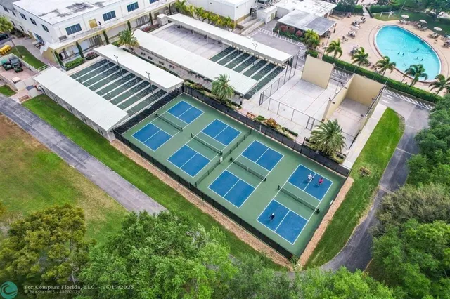 an aerial view of a tennis ground with a large tree