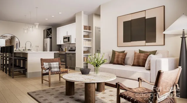 a living room with furniture a flat screen tv and kitchen view